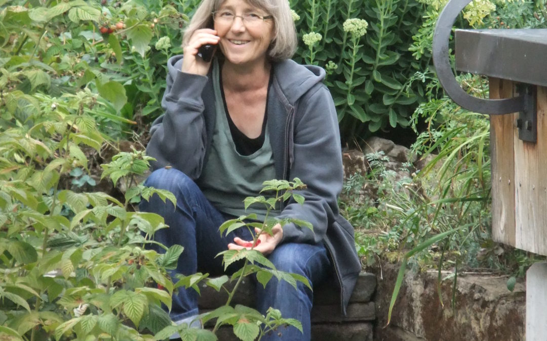 Stefanie Seemann sitzt in ihrem Garten und telefoniert
